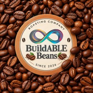 BuildABLE Beans Roasting Company badge on a bed of roasted coffee beans